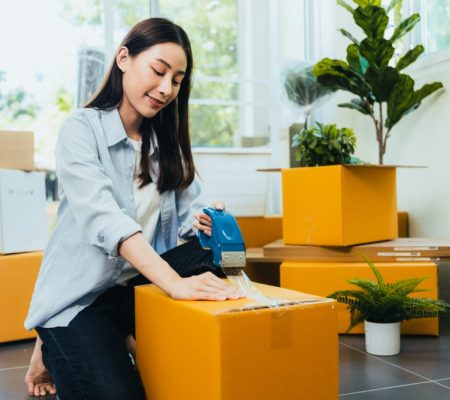 Asian woman packing box to move new home